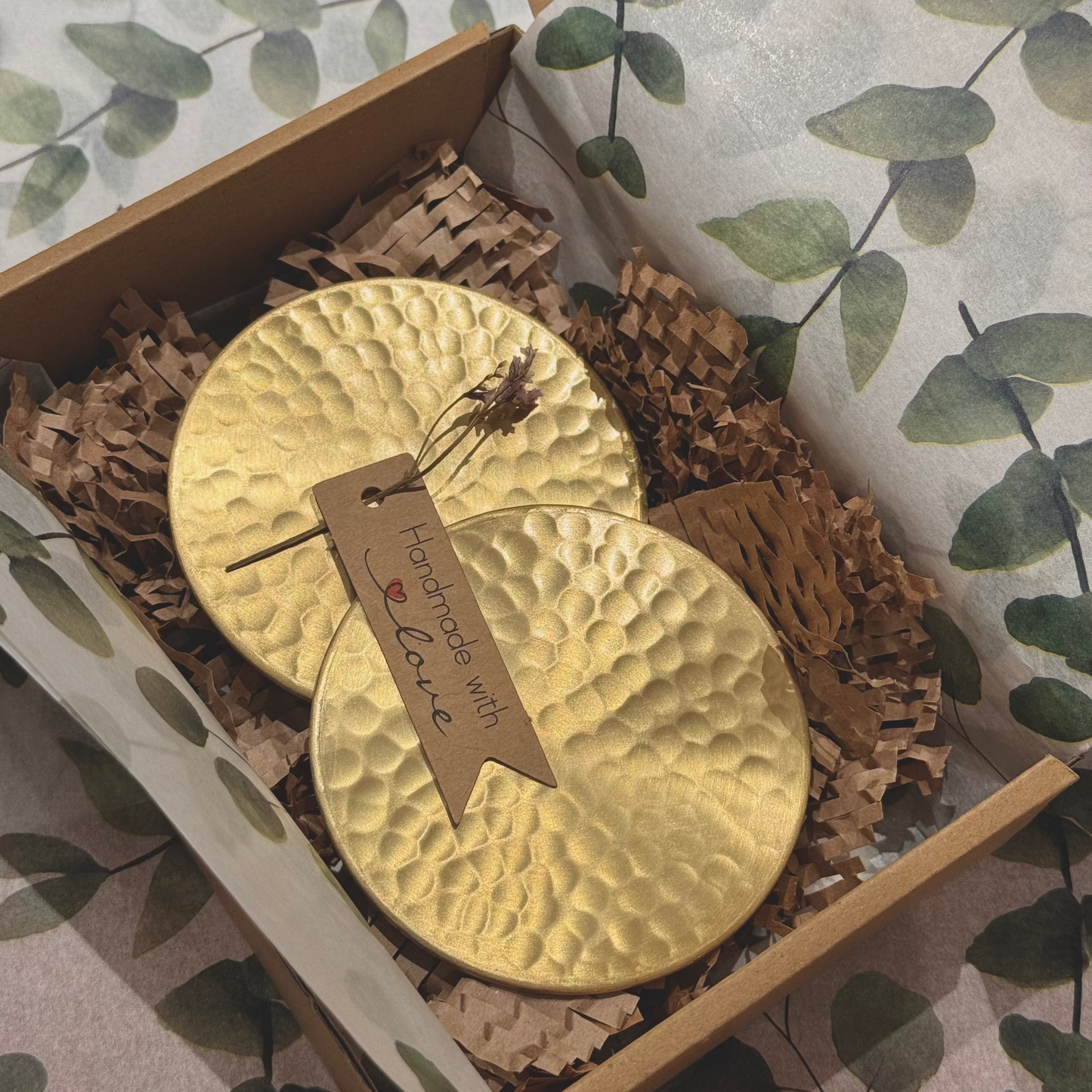 Gold coasters with a tag in a box with decorative paper