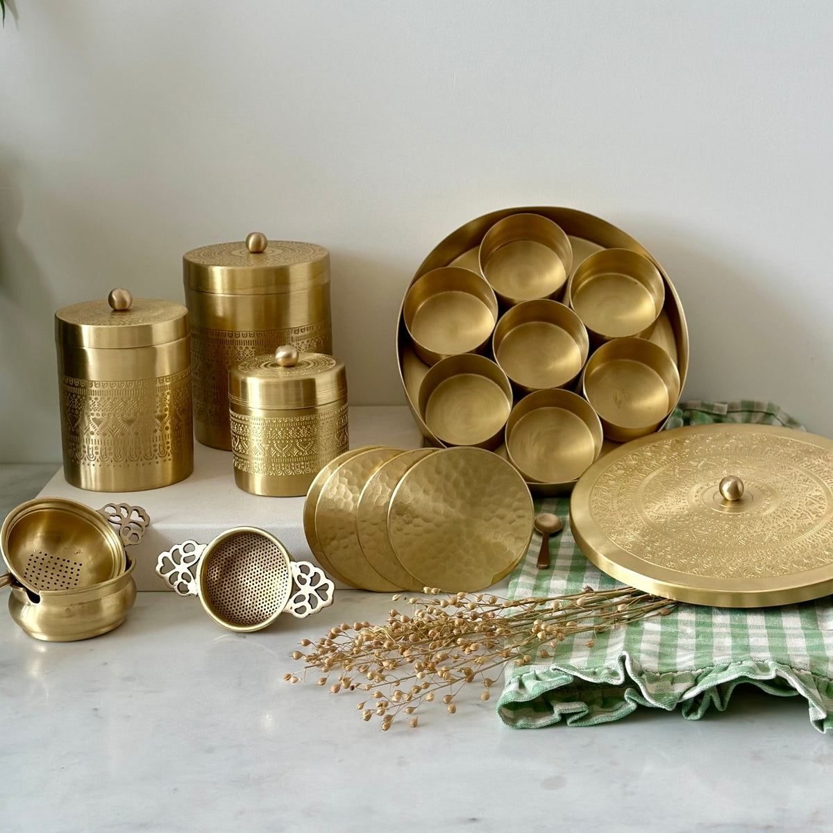 Compact brass tea strainer on the counter, Vaarsa London