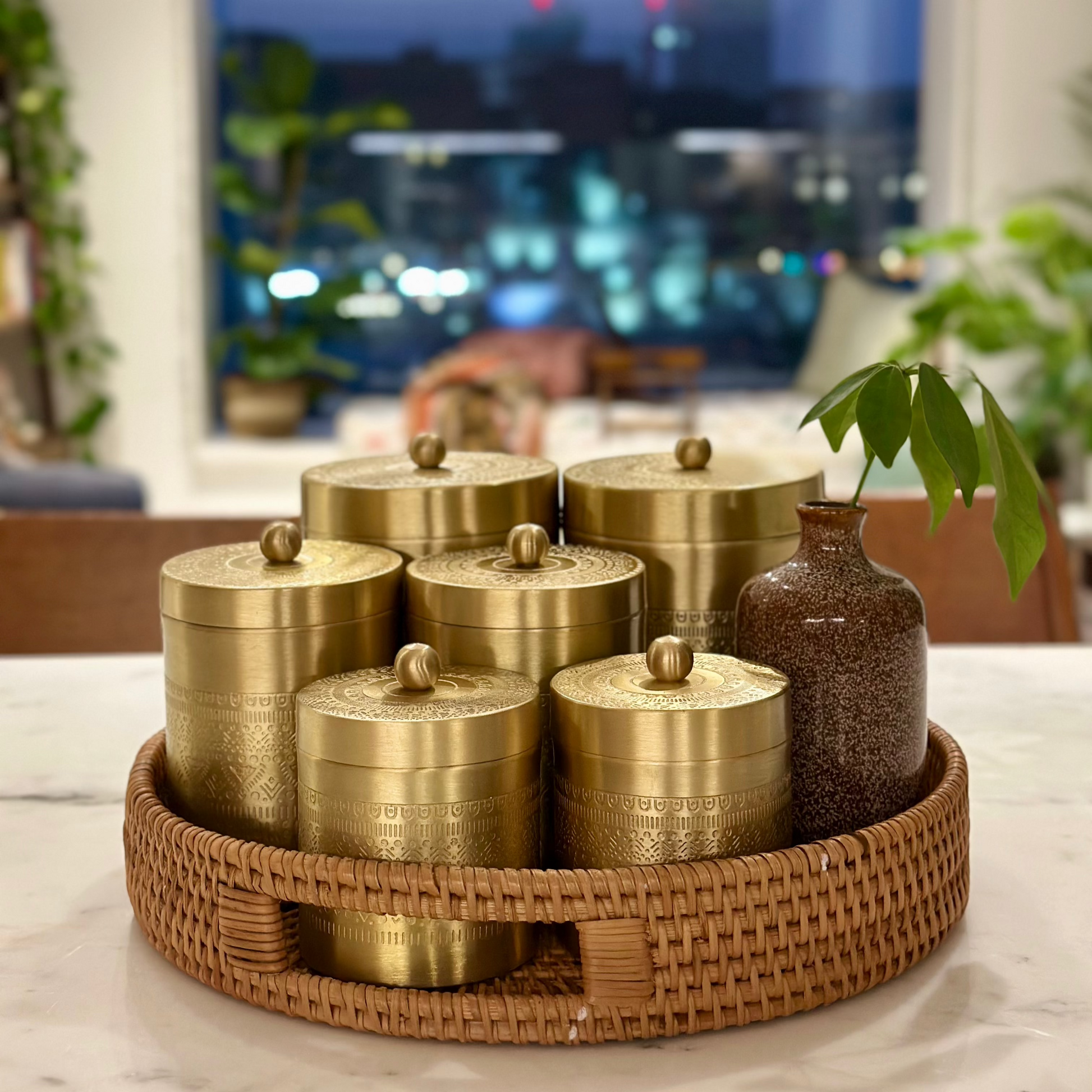 Set of three brass storage jars in a woven basket, Vaarsa London