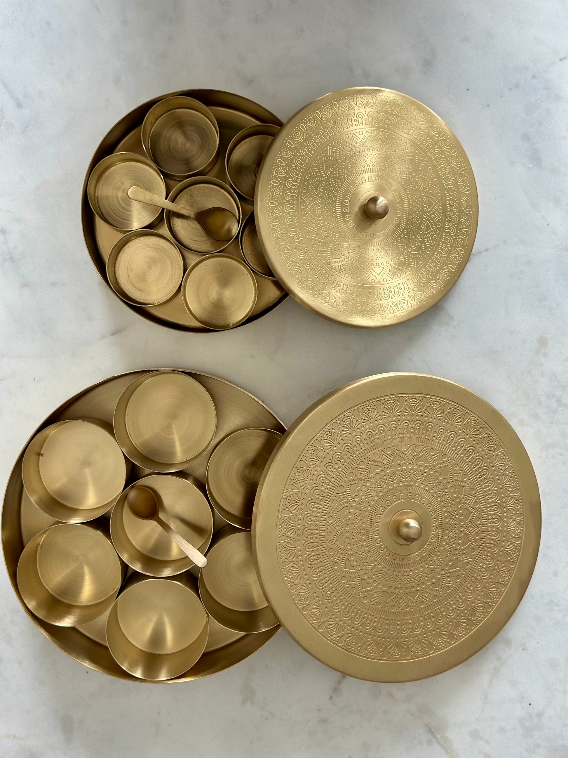 Gold decorative items with intricate designs on a marble surface
